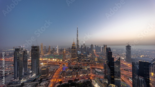 Aerial panorama view of tallest towers in Dubai Downtown skyline and highway day to night .