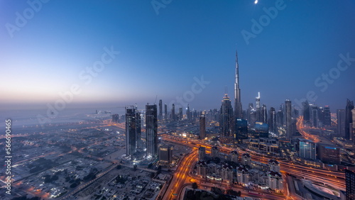Aerial view of tallest towers in Dubai Downtown skyline and highway night to day .