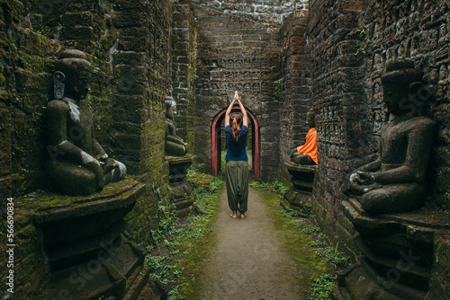 Woman with raised hands in spiritual Buddhist place photo