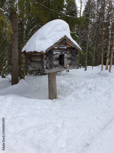 A wooden dovecote covered in snow