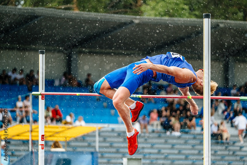 Obraz na plátne unsuccessful attempt athlete high jump in rain