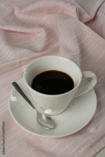 Cup of aromatic coffee on white wooden table