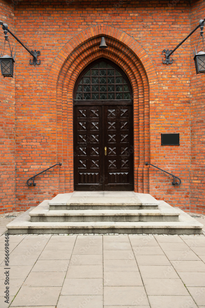 Fototapeta premium Entrance of building with beautiful arched wooden door