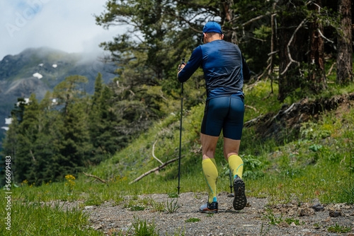 male athlete with trekking poles during vertical kilometer