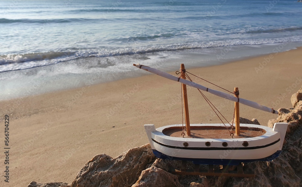 Model of a ship on the beach of the sea background . A dream of travel