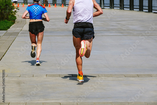 man and woman runners run marathon in riverfront photo