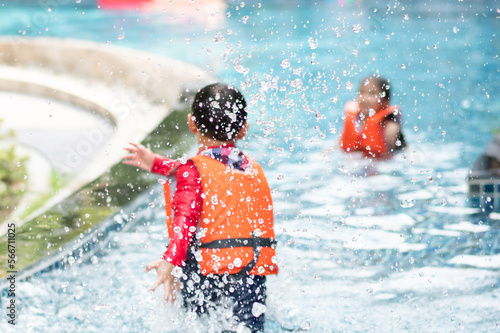 Background of kids playing splash water in swimming pool together on summer © winnievinzence
