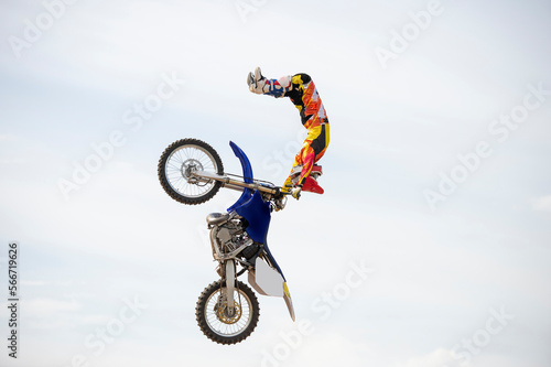 Unknown rider jumping with motocross motorcycle in freestyle mode photo