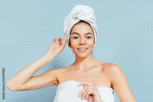 Close-up of a happy woman with her head wrapped in a white terry towel photo