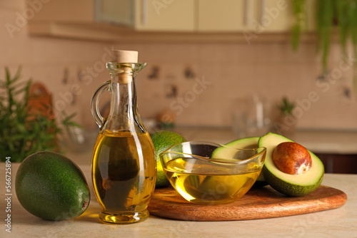 Fresh avocados and cooking oil on beige marble table in kitchen