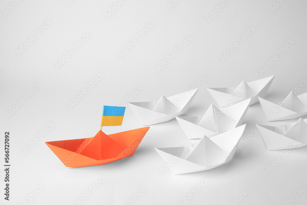 Group of paper boats following orange one on white background. Leadership concept Group of paper boats following orange one on white background. Leadership concept