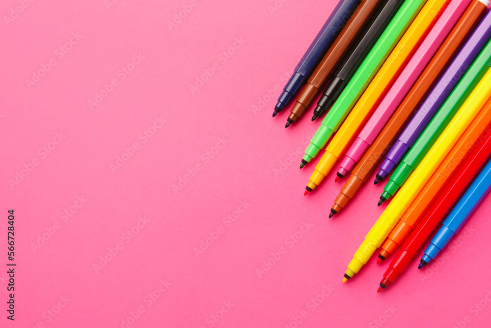 Many bright markers on pink background, flat lay. Space for text Many bright markers on pink background, flat lay. Space for text
