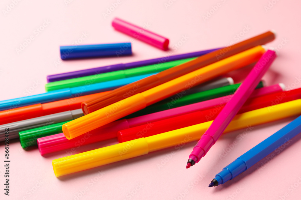 Many bright markers on pink background, closeup Many bright markers on pink background, closeup