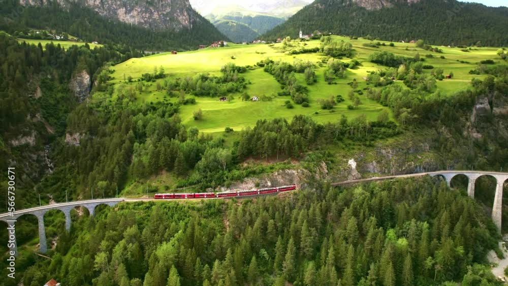 Drone Switzerland 4k. Glacier Express red swiss train in Swiss Alps. Rhaetian Railway famous Landwasser viaduct bridge. Zermatt to St. Moritz. Switzerland summer tourism.