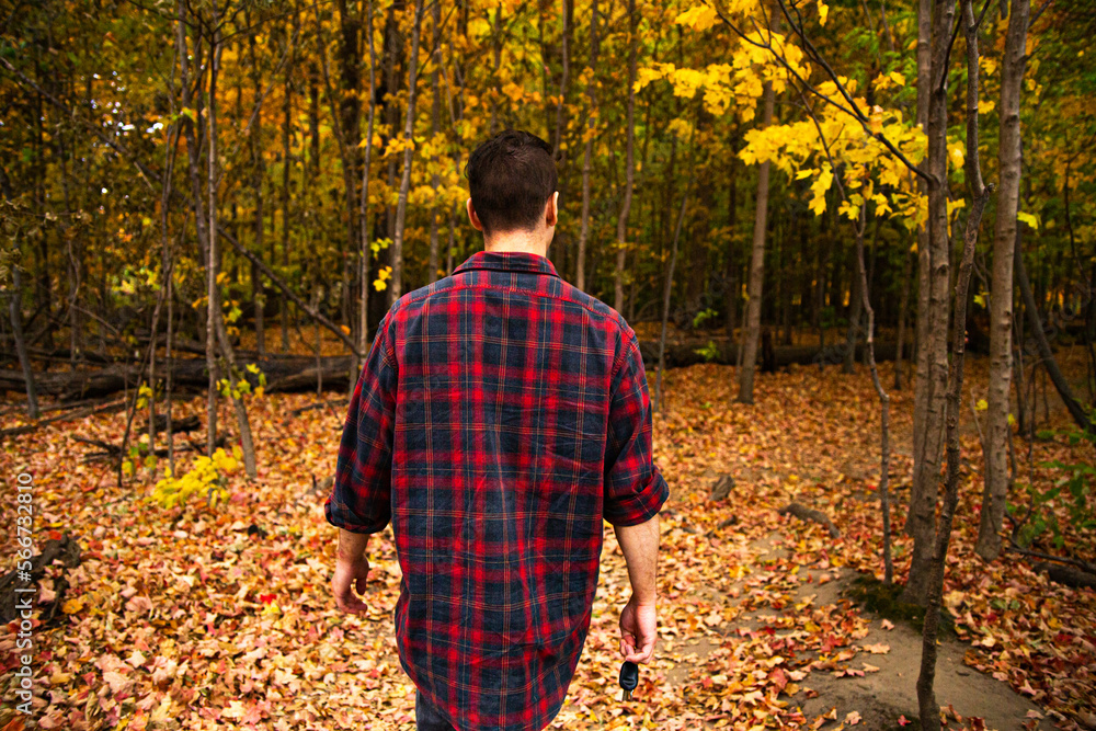 A man walking in a forest and grass field in Canada.