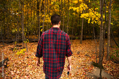 Photography A man walking in a forest and grass field in Canada.