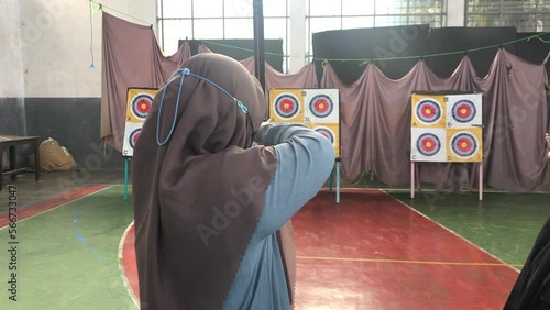 Bandung, Indonesia- 30-01-2023 : muslim woman is playing archery indoors photo