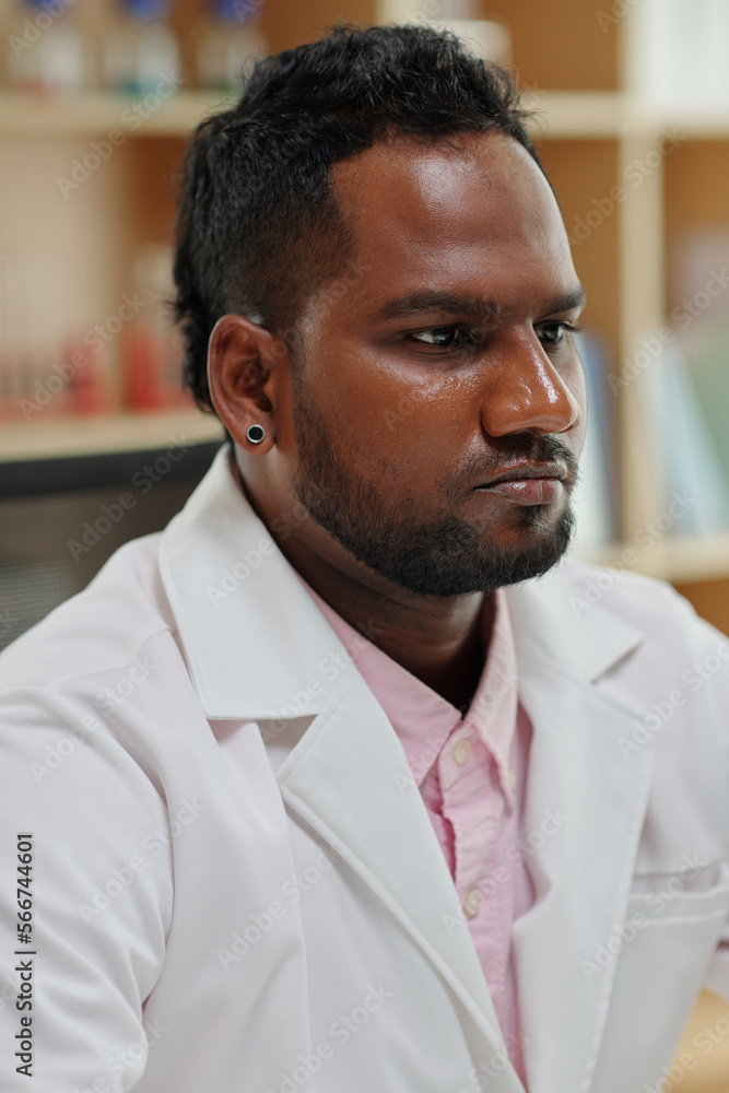 Portrait of pensive serious scientist in white labcoat Portrait of pensive serious scientist in white labcoat