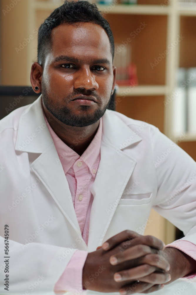 Portraint of serious head of medical laboratory sitting at his desk Portraint of serious head of medical laboratory sitting at his desk