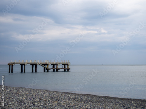 Reinforced concrete sticking out of the water. Remains of an old bridge in the sea. Ruined pier. Abandoned. Armature at sea.