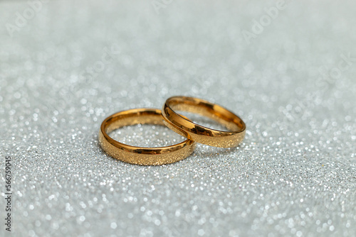 Will you marry me. Two golden wedding rings on silver glitter background. Engagement marriage proposal wedding concept. St. Valentine's Day postcard. Banner on valentines day. Copy space.