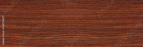 Rosewood texture. Texture of dark mahogany with an intense pattern, natural rosewood veneer for the production of furniture or yacht decoration photo