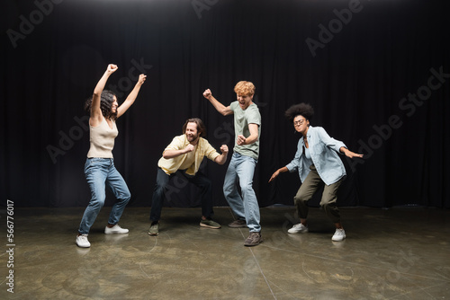 Obraz na plátně full length of excited interracial students posing in acting skills studio