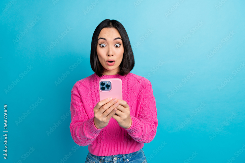 Photo of impressed indonesian lady pouted lips use telephone unbelievable isolated on blue color background Photo of impressed indonesian lady pouted lips use telephone unbelievable isolated on blue color background
