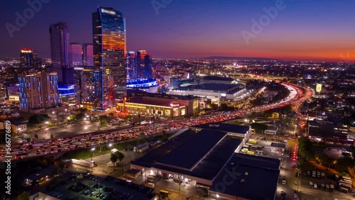 Urban aerial view or drone shot of busy downtown Los Angeles California in USA at night with freeway traffic and LA Convention Center time lapse.