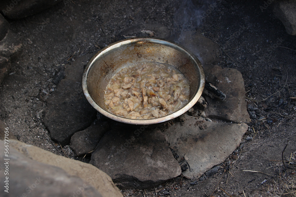 A place for a bonfire made of stones in nature, coals, a bowl with mushrooms. A place for a bonfire made of stones in nature, coals, a bowl with mushrooms.