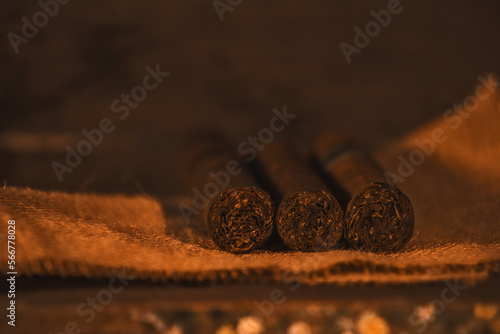 Photography Handmade Caribbean tobacco cigar, on rustic wooden table with coppery colors and