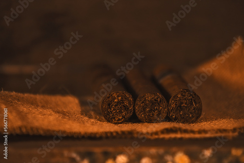 Handmade Caribbean tobacco cigar, on rustic wooden table with coppery colors and low lighting