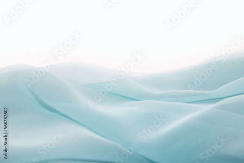 Wavy surface of a pastel blue chiffon fabric as a background with copy space. Photo in perspective