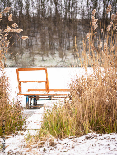 Pier at the frozen lake with snow