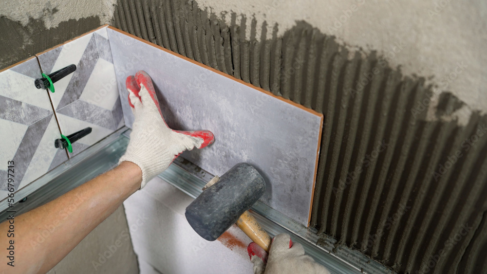  Adjustment of ceramic tiles with a rubber mallet. Hammer with rubber ...