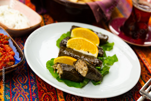 Delicious wrapped vine leaves stuffed with rice served with fresh lemon. Traditional dish Sarma (or Dolma) in Turkish cuisine