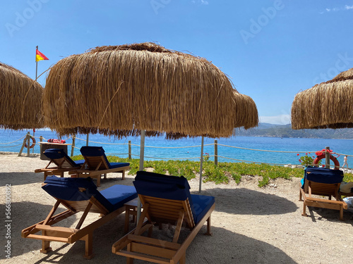 sunbeds, umbrellas and green lawns with sea view. Relaxation, sunbathing and rest area , selective focus blur, Antalya, Ölüdeniz, lykia, 2022