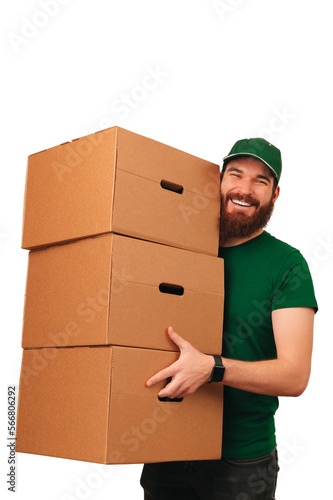 Vertical shot of a strong bearded delivery man lifting up three big boxes. © Vulp