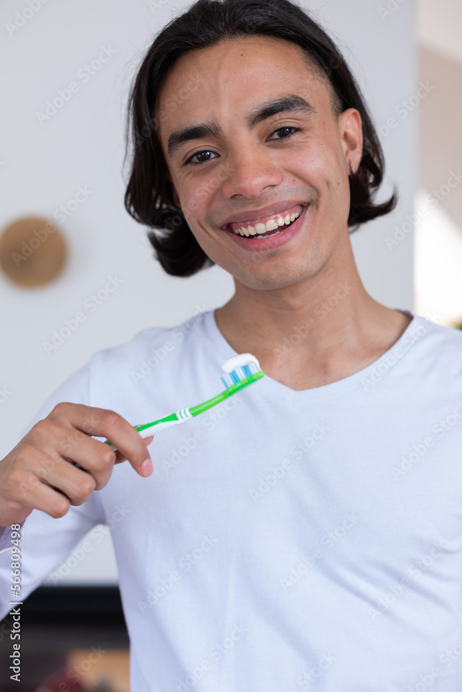 Portrait of happy biracial man brushing teeth in bathroom Portrait of happy biracial man brushing teeth in bathroom