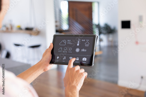 Canvastavla Hands of biracial man at home using tablet with smart home interface on screen