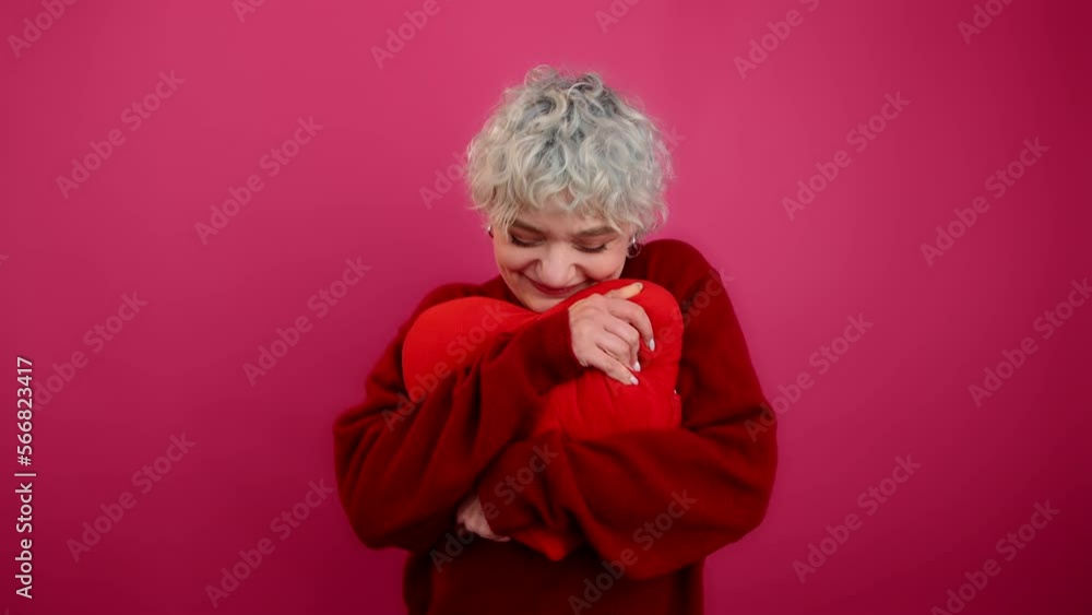 Close-up view of caucasian woman holding heart-shaped cushion. Portrait of happy, smiling girl celebrating Valentine's Day. High quality 4k footage Close-up view of caucasian woman holding heart-shaped cushion. Portrait of happy, smiling girl celebrating Valentine's Day. High quality 4k footage