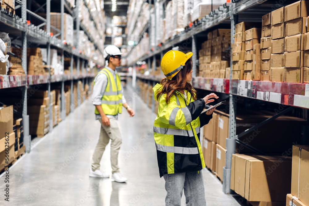 Asian two engineer team shipping order detail on tablet check goods and supplies on shelves with goods background inventory in factory warehouse.logistic industry and business export Asian two engineer team shipping order detail on tablet check goods and supplies on shelves with goods background inventory in factory warehouse.logistic industry and business export