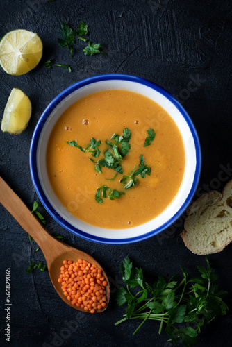 Red lentil soup puree in a bowl  on dark background. Traditional middle eastern cuisine. Vegan food.