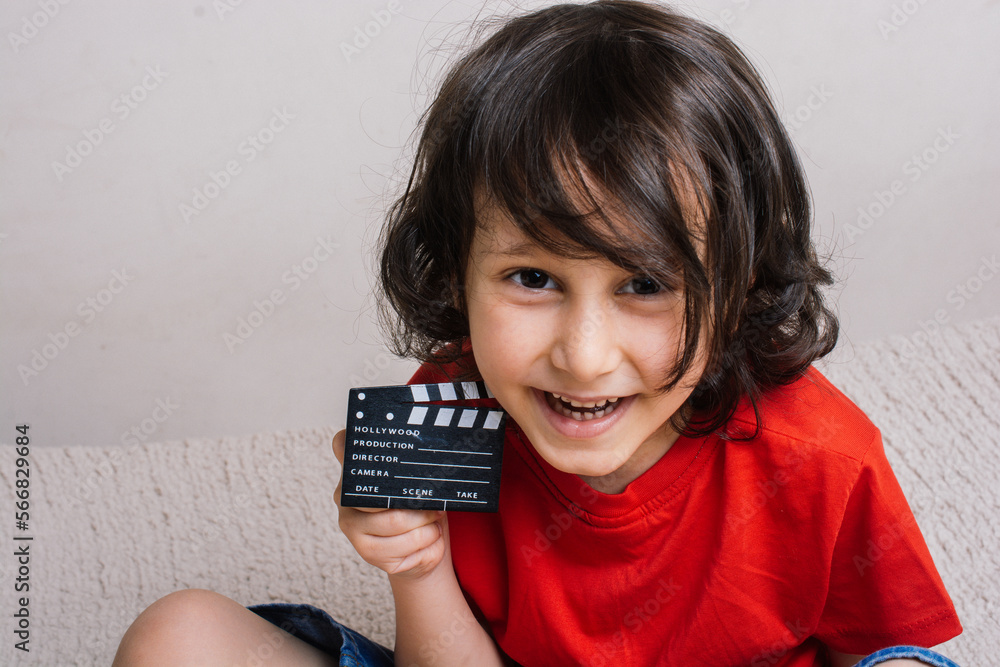 Little boy holding a with a movie clapperboard Little boy holding a with a movie clapperboard