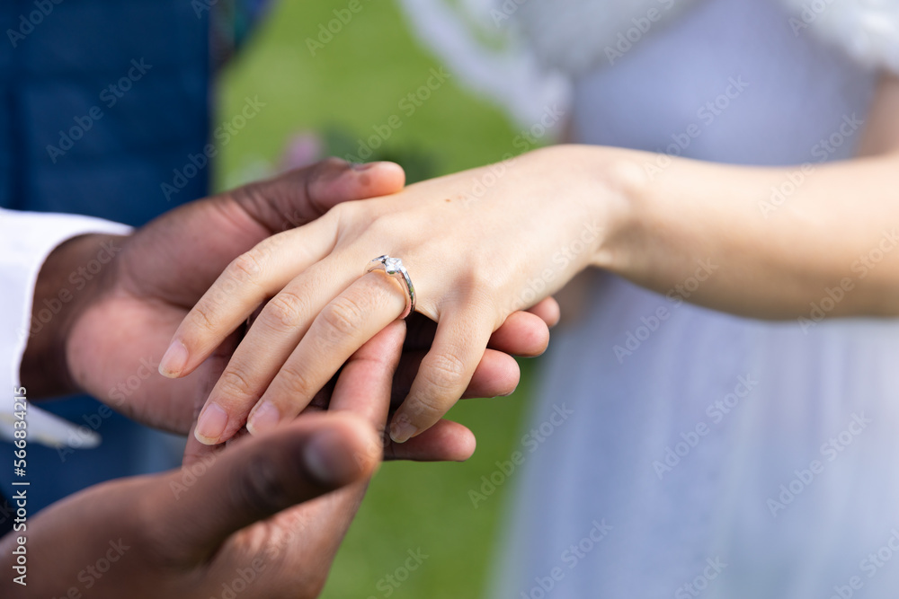 Hands of diverse groom and bride wearing wedding ring at outdoor wedding, copy space Hands of diverse groom and bride wearing wedding ring at outdoor wedding, copy space