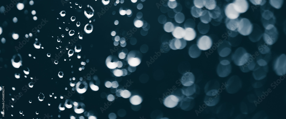 Atmospheric minimal monochrome backdrop with rain droplets on glass. Wet window with rainy drops and dirt spots closeup. Blurry minimalist background of dirty window glass with raindrops close up.