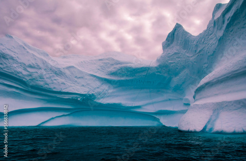 Blue iceberg in polar regions with pink sky

