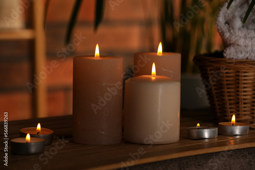 Spa composition with burning candles on massage table in wellness canter