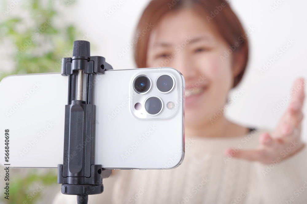 Naklejka premium 固定されたスマホに向かってしゃべる女性