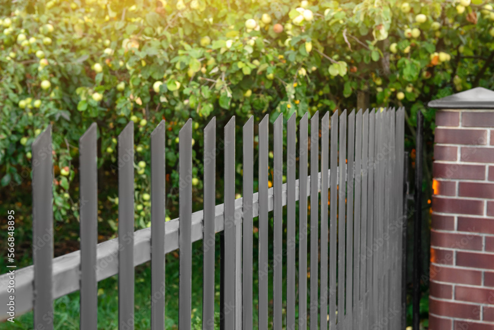 Beautiful brick fence with iron railing outdoors Beautiful brick fence with iron railing outdoors